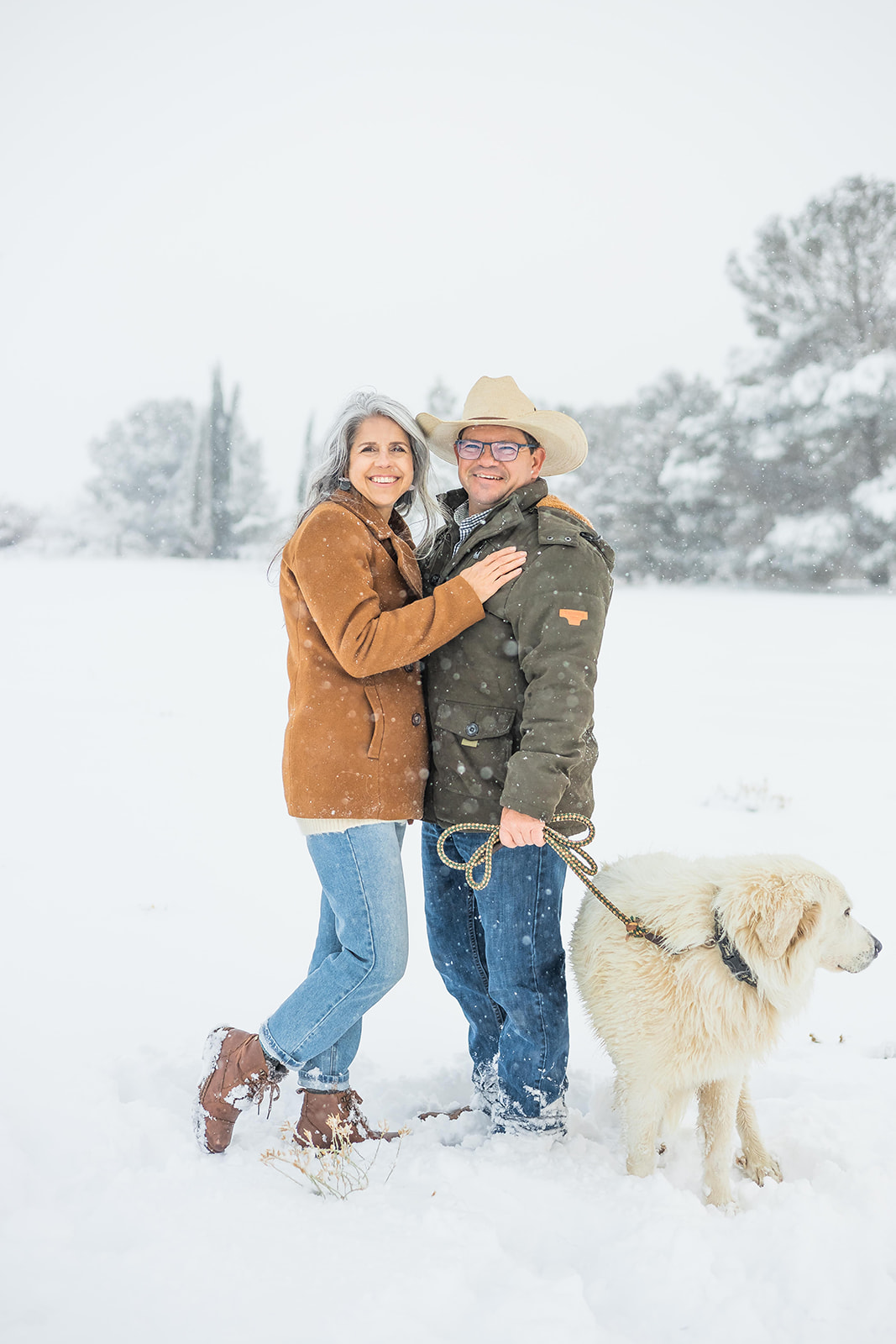 Mike and Linda standing in the snow with their dog